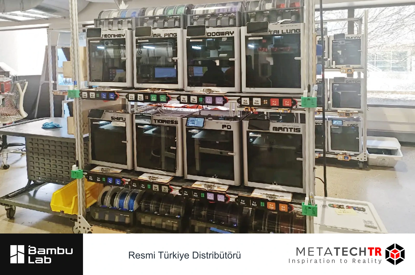 Raflara yerleştirilmiş, etiketli Bambu Lab yazıcılar ve filament makaraları.