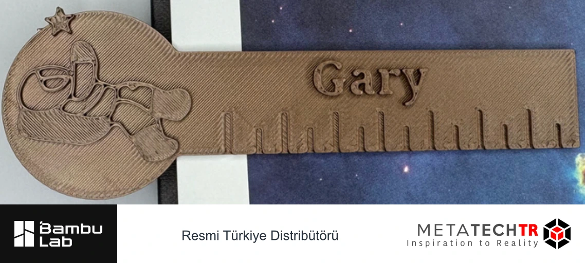 Gary yazılı, astronot figürlü ve cetvel işaretli basılı kitap ayracı.